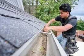 Technician cleaning debris from a gutter